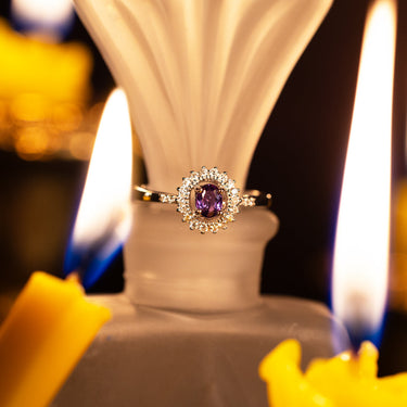 0.40ct natural alexandrite ring in 18k white gold with diamond halo, showcasing vivid purple-green color change gemstone under warm candlelight
